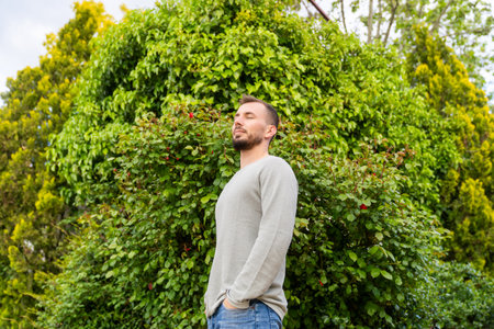 Man breathing fresh air in green lush gardenの写真素材