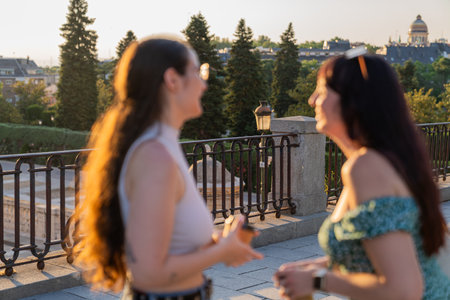Friends enjoying sunset conversation overlooking madrid skyline in spainの写真素材