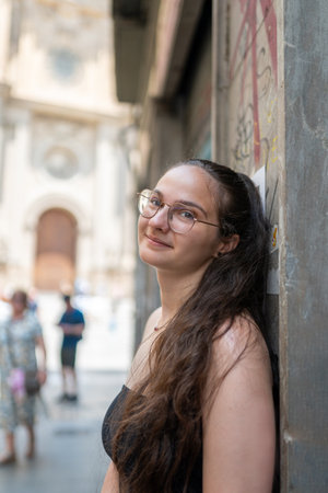 Young woman leaning against wall in valencia city center, spain