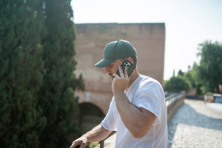 Tourist wearing a green cap talking on smartphoneの写真素材