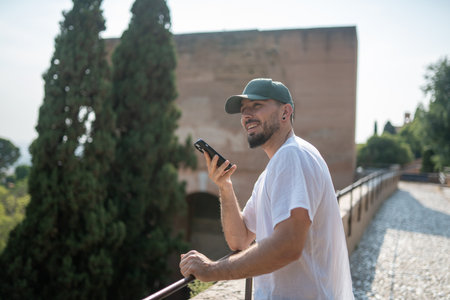 Tourist using voice assistant on smartphone while looking up thinking
