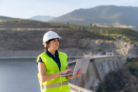 Female engineer working with laptop at dam construction siteの写真素材
