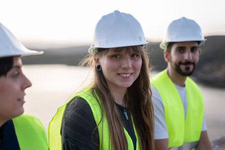 Young engineers wearing safety vests and helmets promoting technical careers