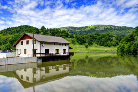 House reflected in lake Taria, Romaniaのeditorial素材
