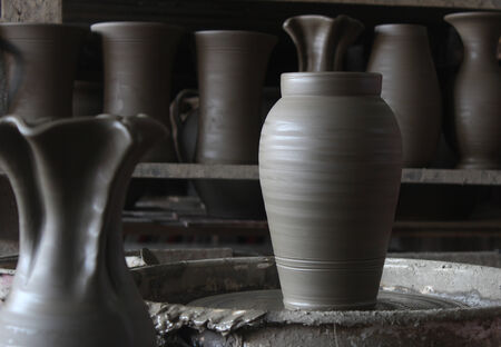 Unfinished ceramic vase on wheel in pottery workshop