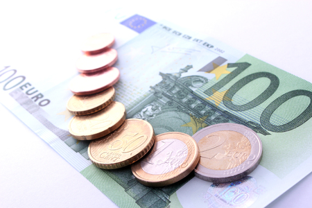 studio shot of complete set of euro coins on 100 euro bank note. symbol for european economy, business, banking and financeの写真素材