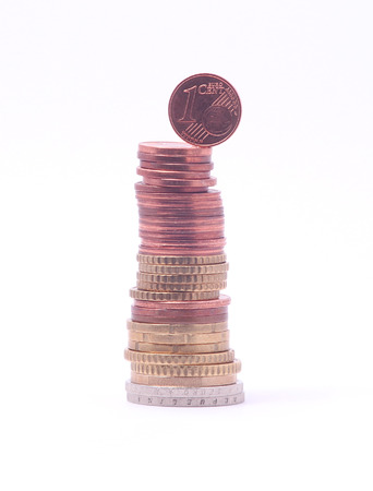 1 cent coin falling from stack of euro coins. Symbol for economy, business, income, banking, finance, leadership, progressの写真素材