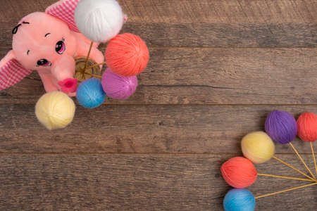Close up view of yarn balls and pink elephant