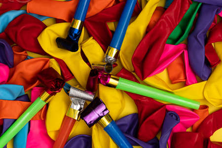 Birthday party whistles and colorful deflated balloonsの写真素材