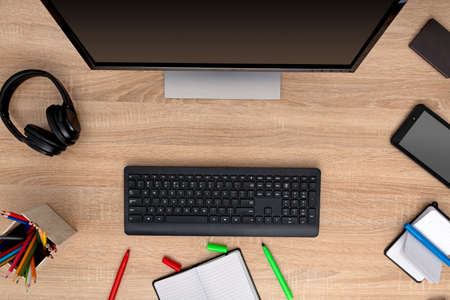 Colorful pencils in wooden box with computer technicsの写真素材