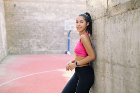 Sport girl leaning against wall at playgroundの写真素材