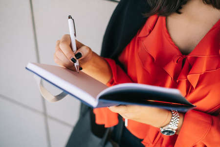 Cropped image of girl writing in her notebookの写真素材