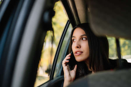 Young woman talking on cell phone in automobileの写真素材