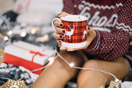 Close-up of girl warming her hands on cupの写真素材