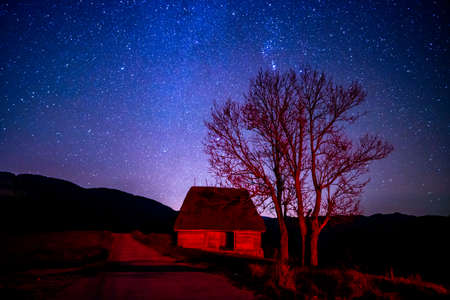 Romanian rural night landscape with hay shed under the starry skies, up in Trascau Mountains, Dumesti village, Alba county.の写真素材