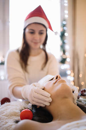 Brunette woman enjoying face massage in SPA salonの写真素材