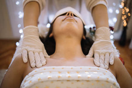 Therapist hands touching womans shoulders in SPA salon