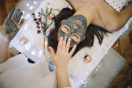 Beautician applying mask to the face of a woman
