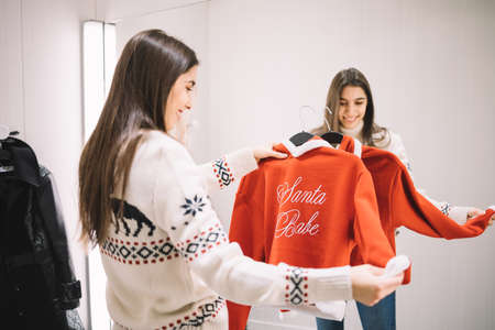 Woman holding blouse on hanger in dressing roomの写真素材