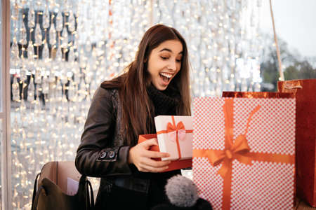 Surprised woman looking into opened Christmas gift boxの写真素材