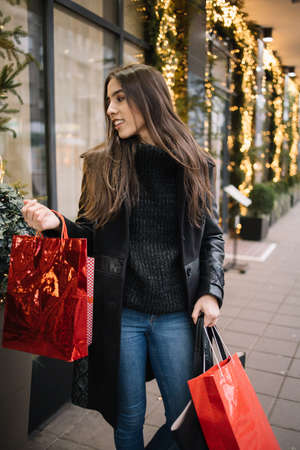 Beautiful woman with shopping bags walking on the streetの写真素材