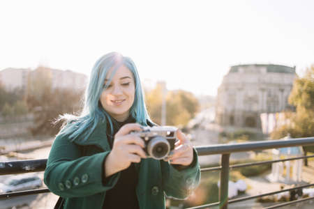Happy woman taking photo with retro camera