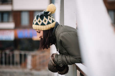 Girl looking river leaning on bridge fenceの写真素材