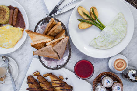 Top-view of breakfast with egg white omelette and asparagus. Table with variations of food with...