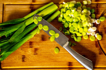 Top view of chopped spring garlic on wooden boardの写真素材