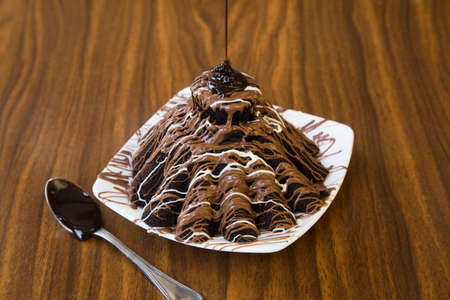 Dessert with chocolate toppings on wooden tableの写真素材