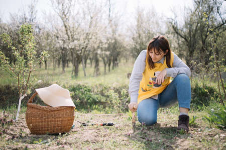 Woman sitting in backyard with gardening tools