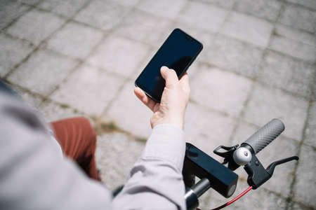 Mans hand holding black smartphone with blank screenの写真素材