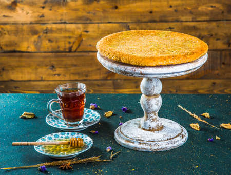 Traditional arabic dessert with kadayif on stand. Oriental dessert knafeh on cake stand on table...