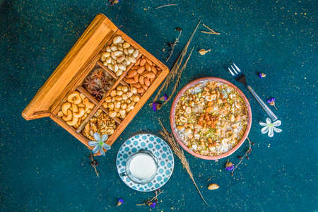 Oriental dessert Om Ali with nuts and raisins. Top view of table with Egyptian bread pudding on table with cup of milk and box with nuts.の写真素材