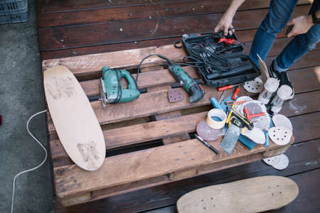 Tools for making skateboard on pallet in workshop. Top view of wooden pallet with handyman tools and...