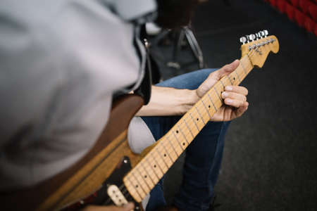 Close-up view if male musician playing electric guitar. Cropped image of hands of male guitar player playing electric guitar.の写真素材