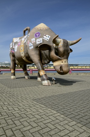 Traveler cow was made as old, shabby leather traveling bag, which is glued with different symbols of those countries and cities where the tourist was, and stickers of where the cow was の写真素材