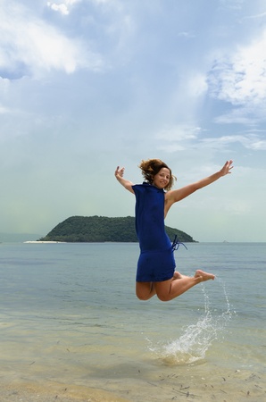 Beautiful girl jumping in tropical seaの写真素材