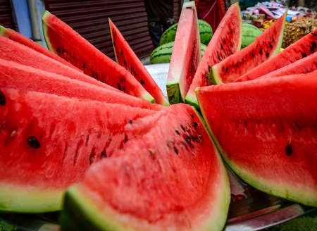 Close-up of fresh slices of red watermelon at a street marketの写真素材