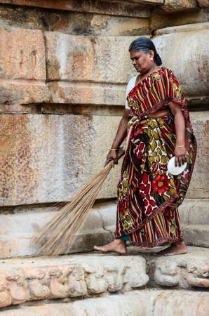 THANJAVUR, INDIA - FEBRUARY 14: An unidentified Indian woman in national dress carries sweeping a broom at Brihadishwara Temple. India, Tamil Nadu, Thanjavur. February 14, 2013.のeditorial素材