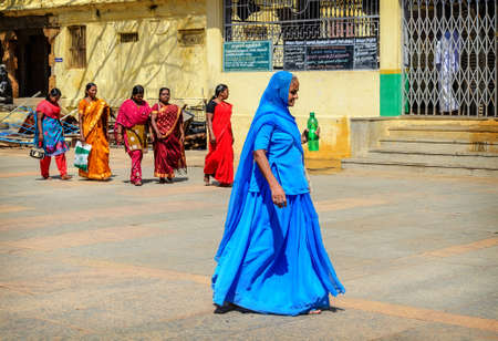 MADURAI, INDIA - FEBRUARY 16: An unidentified Indian woman in blue national dress and group of Indian woman in beautiful saree walking in Meenakshi Temple  on Feb 16, 2013. India, Madurai, Tamil Naduのeditorial素材