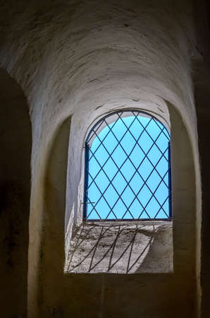 Window with a grid and blue skies in a castle