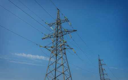 High-voltage tower isolated on blue sky background.の写真素材