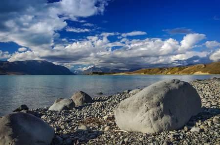 Big stones on the shore Lake Tekapo on a  mountains. South Island, New Zealand