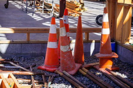 Group of old shabby traffic cones stacked and nested together. Plastic orange and white reflective...
