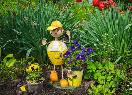 Wooden garden sculpture of boy in home garden.の写真素材