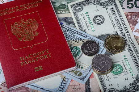 The Russian passport in a red cover lies on a pile of  foreign currencies