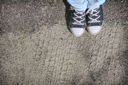 Blue sneakers shoes walking on old grange dirty concrete top view.の写真素材