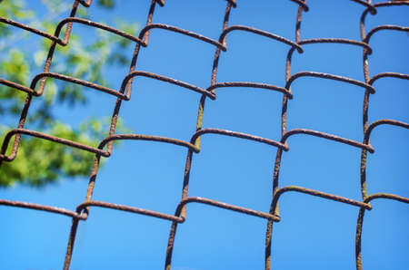 iron chain link fence against skyの写真素材