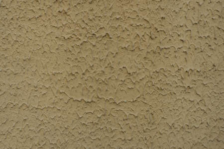Decorative stucco background with textured sand with rough ragged edges yellow dirty colorの写真素材